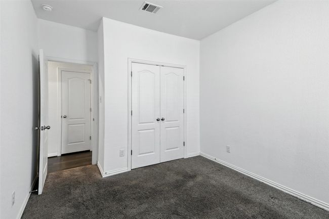 Unfurnished bedroom featuring dark carpet and a closet | Image 20
