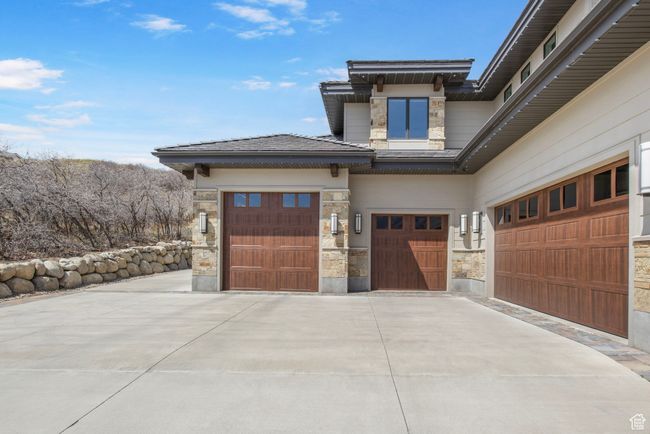 Exterior space featuring a garage, driveway, and stone siding | Image 121