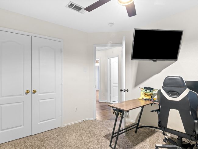 Carpeted home office with a ceiling fan and baseboards | Image 26