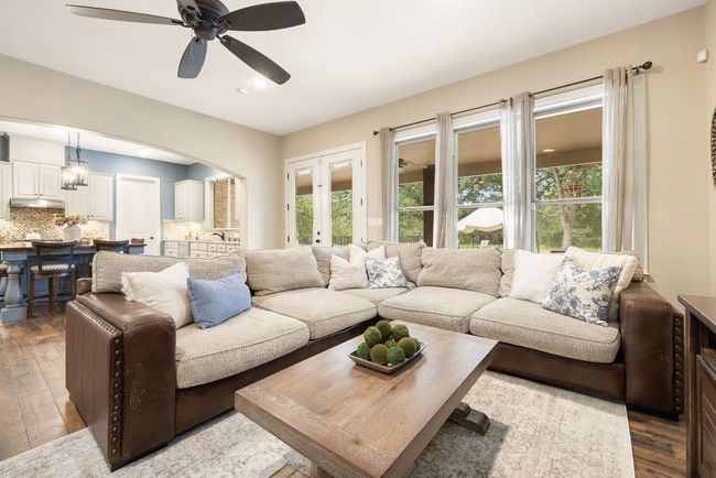 Cozy living room with double doors that lead to the back patio. | Image 11