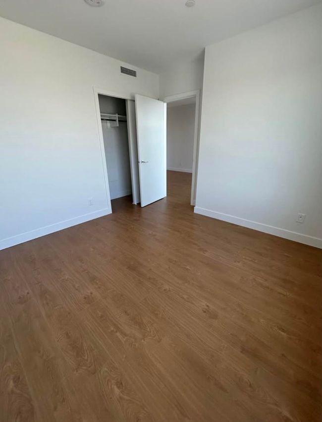 Unfurnished bedroom with dark wood-style flooring, visible vents, and baseboards | Image 10