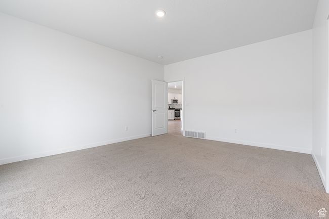 Empty room featuring light colored carpet, visible vents, baseboards, and recessed lighting | Image 9