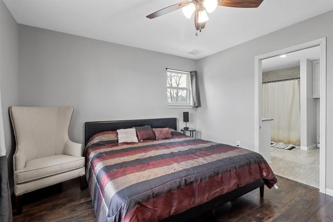 Bedroom featuring a ceiling fan, visible vents, and wood finished floors | Image 13