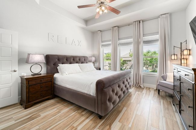 Master bedroom with a raised ceiling, and ceiling fan. | Image 16