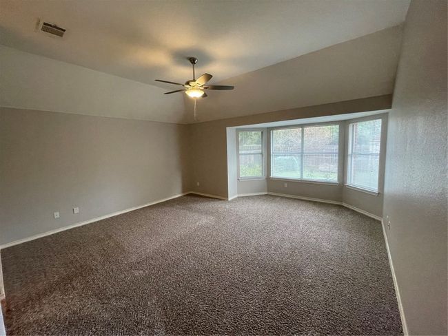 Spare room with ceiling fan, carpet, and vaulted ceiling | Image 22