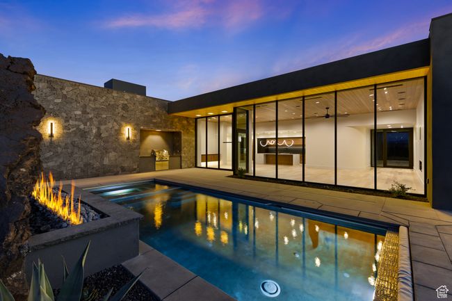 Pool at dusk with a fire pit, a patio area, a pool with connected hot tub, and area for grilling | Image 12