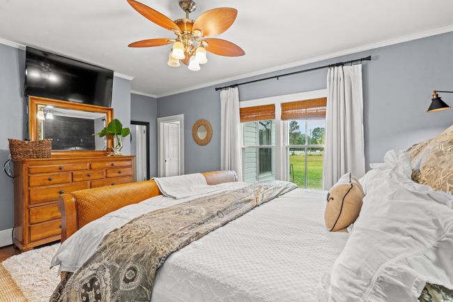 Bedroom with crown molding, a ceiling fan, and wood finished floors | Image 17