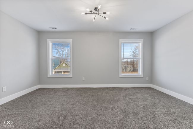 Main level BR or office featuring a wealth of natural light, visible vents, and carpet | Image 16