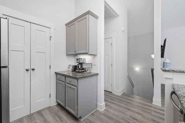 Kitchen with gray cabinetry, light stone countertops, and light wood-type flooring | Image 12