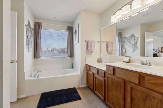 Bathroom featuring a bath, double vanity, visible vents, and a sink | Image 21