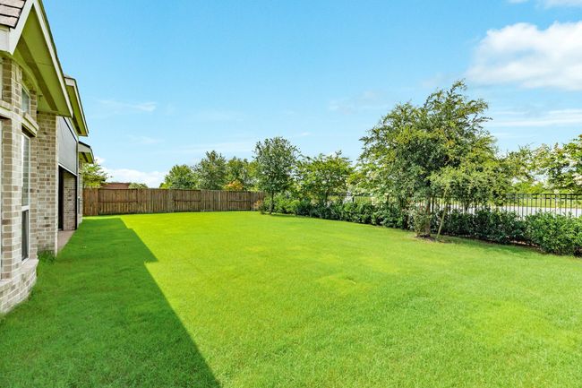The very spacious backyard is surrounded by an iron fence that cases the water front. | Image 47