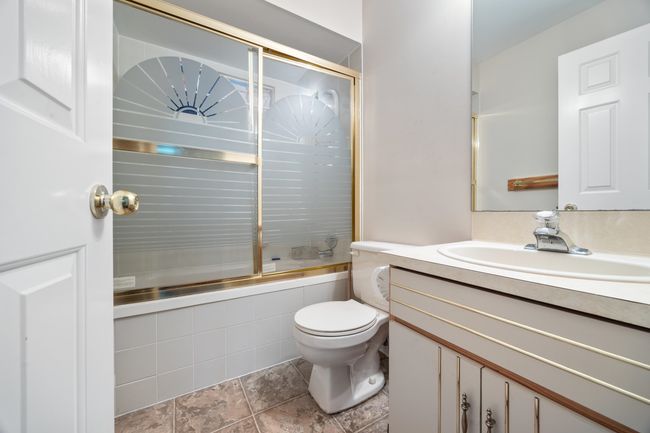 Full bath with combined bath / shower with glass door, toilet, and vanity | Image 5