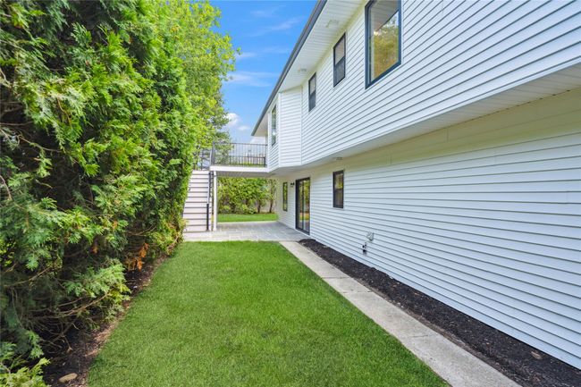 View of grassy yard with stairs and a patio | Image 38