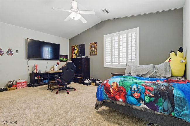 Carpeted bedroom featuring ceiling fan, lofted ceiling, and visible vents | Image 30