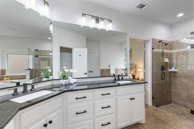 Full bath featuring a sink, a shower stall, tile patterned floors, and visible vents | Image 22