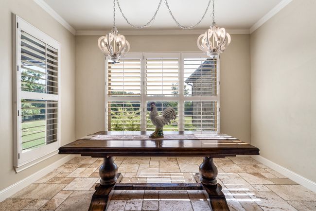 Dining space featuring a chandelier, stone tile floors, healthy amount of natural light, and ornamental molding | Image 18