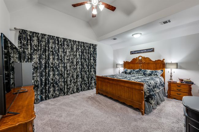 Bedroom with vaulted ceiling, carpet floors, and ceiling fan | Image 16