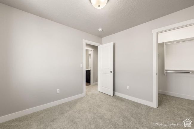 Unfurnished bedroom featuring carpet flooring, baseboards, a closet, and a walk in closet | Image 11