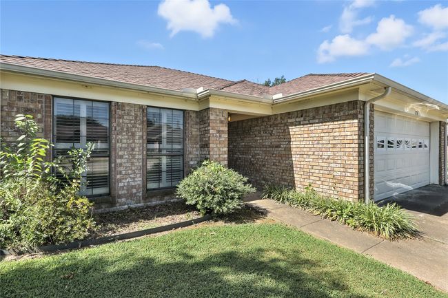 View of front of property featuring an attached garage, brick siding, a shingled roof, and driveway | Image 5