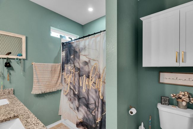 Bathroom with toilet, double vanity, and a shower with curtain | Image 20