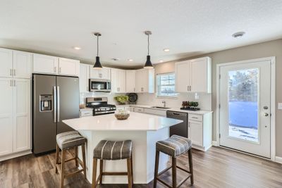 (Photo of decorated model, actual home's finishes may vary slightly) This thoughtfully-designed kitchen layout features quartz countertops, LVP wood flooring, stainless appliances and more! | Image 2