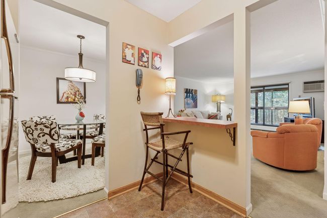 Kitchen pass-through with space for a bar stool, offering a convenient spot to dine or chat with the cook | Image 6