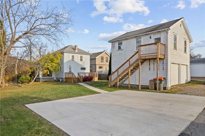 Behind the house is a newer sidewalk, concrete parking pad for 3 vehicles, and a 2 car detached garage, with potential for a one bedroom apartment above it. | Image 2