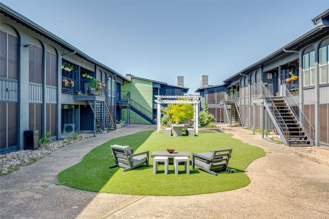 View of home's community with stairs, a wooden deck, and a lawn | Image 23