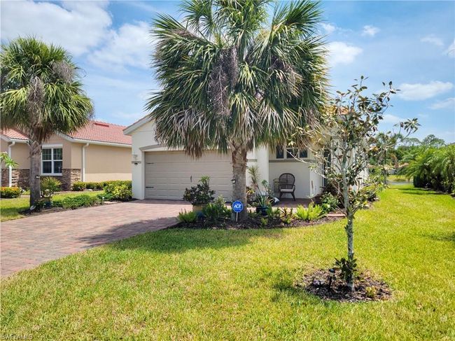 View of front of property with a tile roof, an attached garage, a front yard, stucco siding, and decorative driveway | Image 6