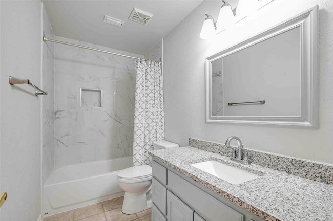 Full bath with visible vents, shower / bath combo with shower curtain, toilet, and vanity | Image 22