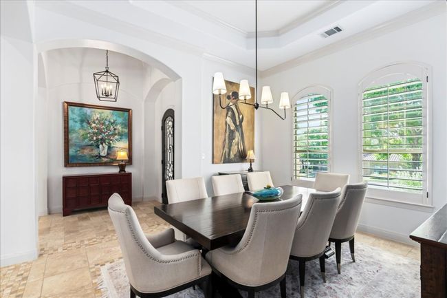 Dining area with a chandelier, healthy amount of natural light, arched walkways, and crown molding | Image 13