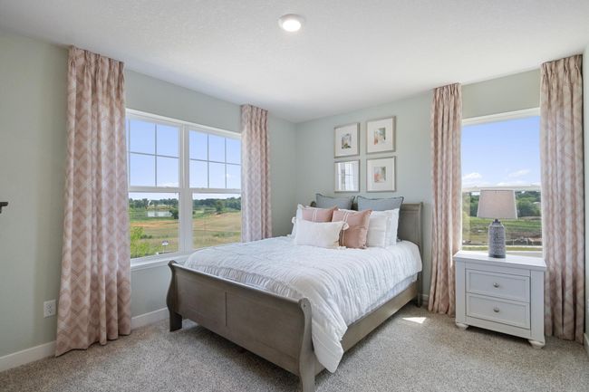 Each of the spacious secondary bedrooms feature well thought out window locations and a walk-in closet. Model photo. Options and colors will vary. | Image 24