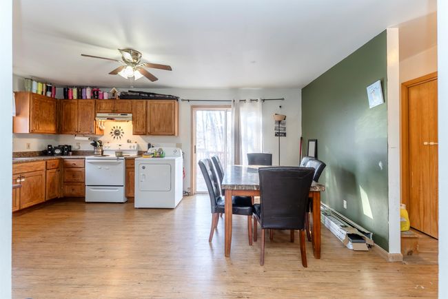 Dining area featuring washer / clothes dryer, light wood-type flooring, and a ceiling fan | Image 25