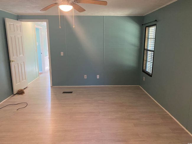 Spare room featuring ceiling fan, wood finished floors, and crown molding | Image 19