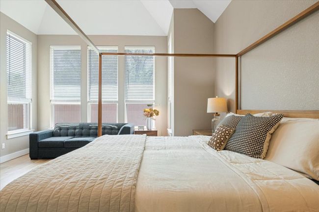 Bedroom with lofted ceiling, multiple windows, wood finished floors, and baseboards | Image 18