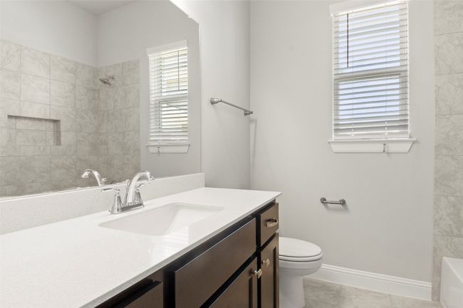 Bathroom featuring vanity, marble look tile flooring, and bathtub / shower combination | Image 31