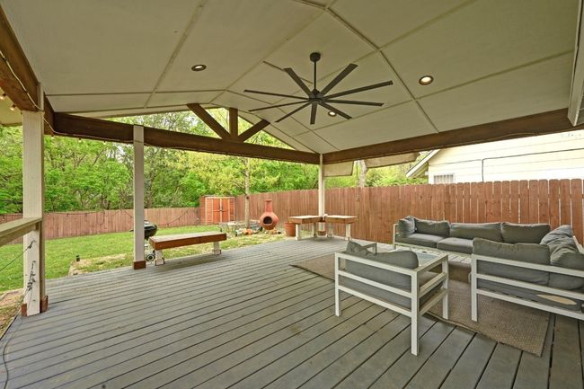 Your living space extends outdoors into this huge covered back deck with a vaulted roof and oversized modern overhead fan. | Image 37