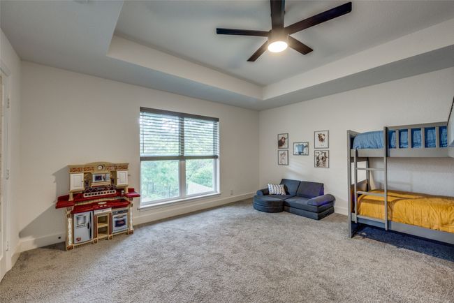 Bedroom featuring carpet floors, a tray ceiling, baseboards, and ceiling fan | Image 18
