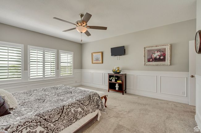 Bedroom featuring wainscoting, ceiling fan, a decorative wall, and carpet | Image 15