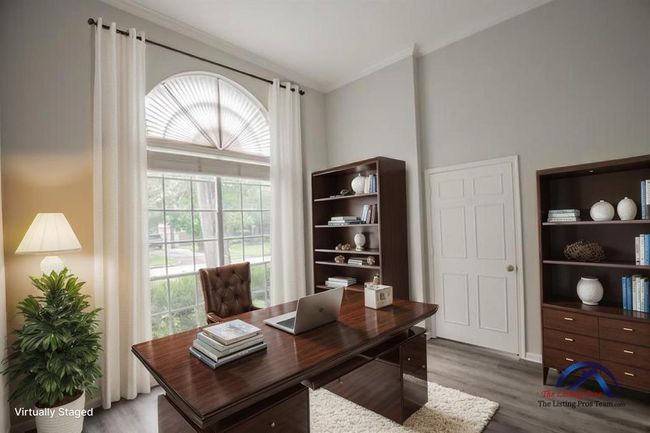 (Virtually Staged) A bright and inviting home office with a large window, creating a professional and comfortable work environment. | Image 11