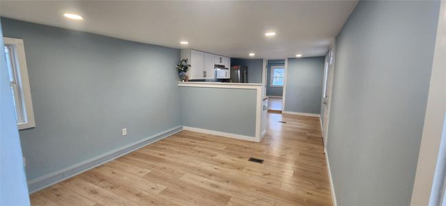 Empty room featuring light wood-type flooring, baseboards, visible vents, and recessed lighting | Image 12