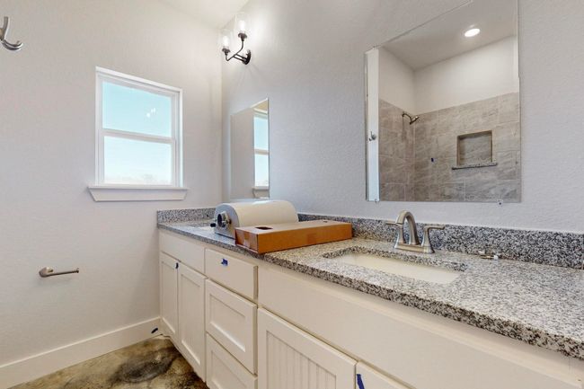 Full bathroom with double vanity, a tile shower, baseboards, and a sink | Image 29