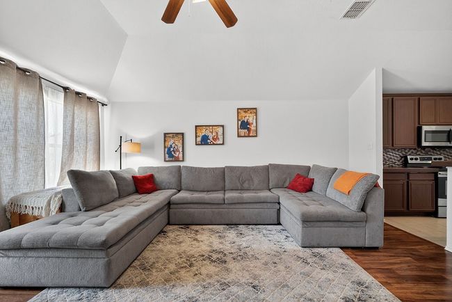 Living room featuring a ceiling fan, dark wood-style flooring, and lofted ceiling | Image 25