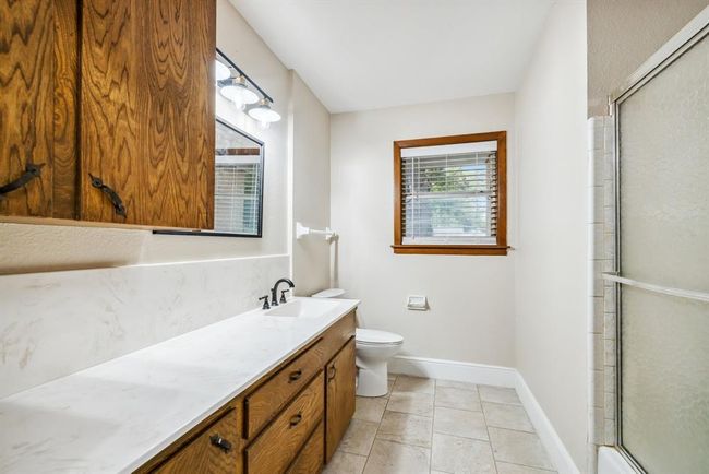 Full bath complete with lots of storage space, counter top space, and bathtub. Updated counter top, faucet, flooring, 2" blinds, light fixture and mirror. | Image 24
