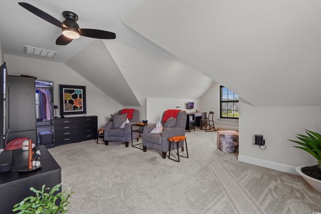 Living area featuring carpet floors, vaulted ceiling, and a ceiling fan | Image 25