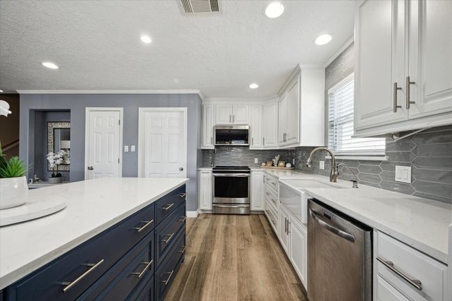 This updated kitchen features ample storage and a convenient pot filler, perfect for culinary enthusiasts. | Image 8