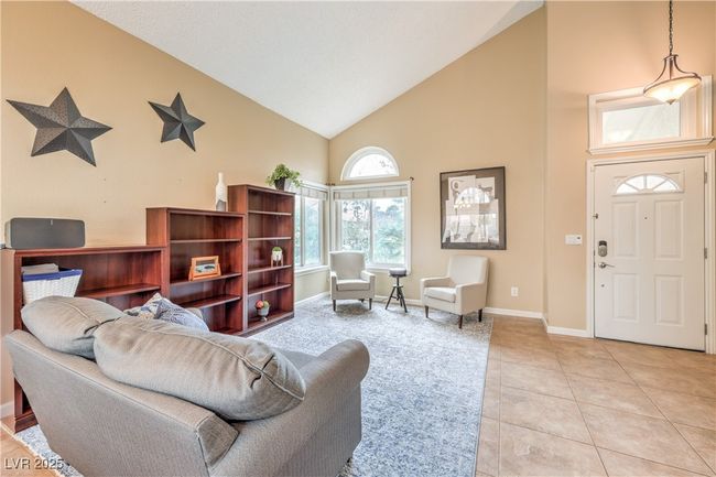 Living room with light tile patterned floors, baseboards, and high vaulted ceiling | Image 8