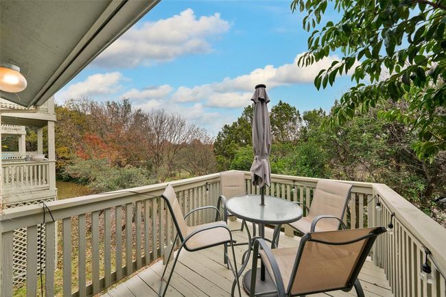 Wooden deck with view of wooded area and outdoor dining space | Image 15