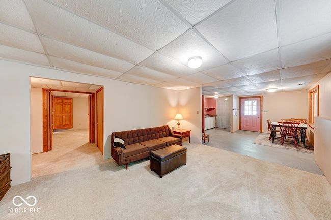 living area featuring carpet and a paneled ceiling | Image 17