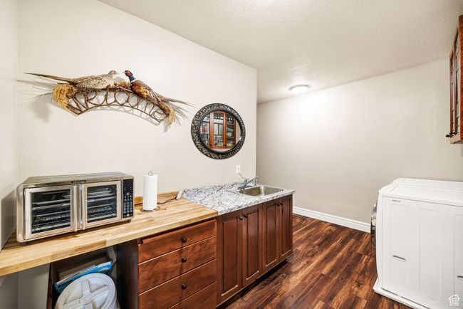 Bar featuring dark wood-style floors, independent washer and dryer, and a textured ceiling | Image 58